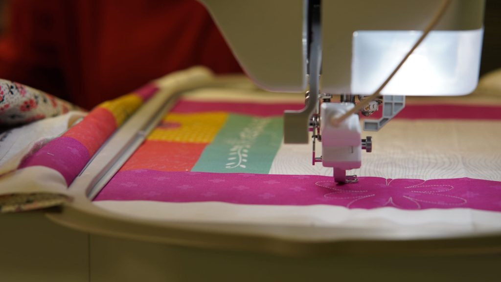 Embroidery machine stitching a quilt in the studio